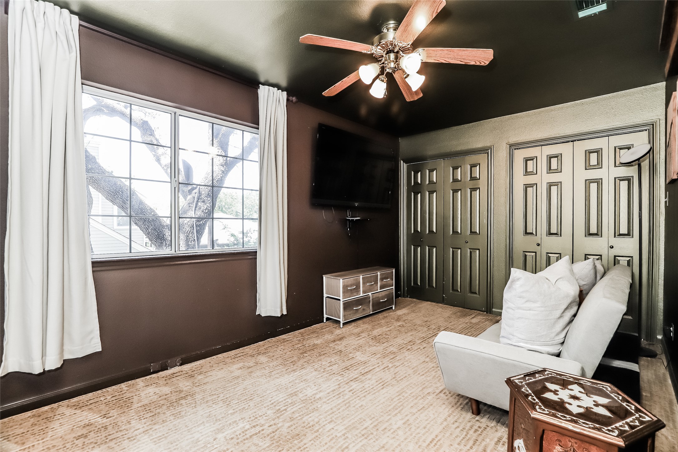 1702 Newning Avenue, Unit A Austin, TX 78704 - Photo 16 of 20 Windowed room featuring textured carpeting, double bi-fold closet doors, and a ceiling fan with integrated lighting