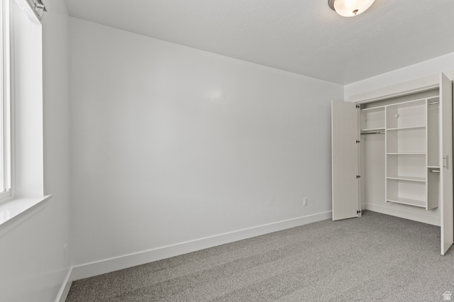 3410 South 1010th Street West Logan, UT 84321 - Photo 11 of 15 Unfurnished bedroom featuring light carpet and a closet