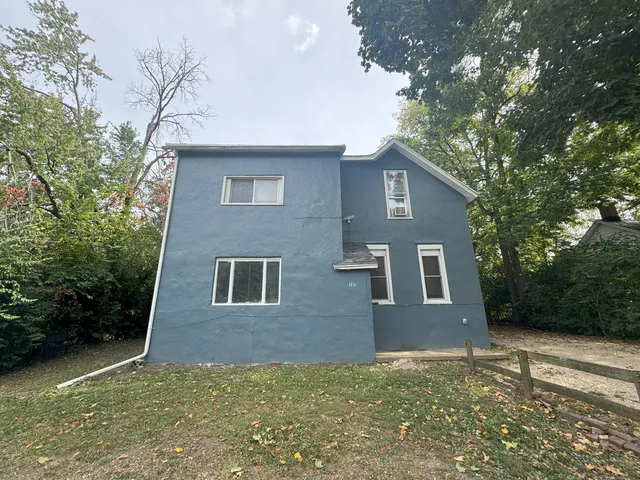 a red brick house with trees in front of it