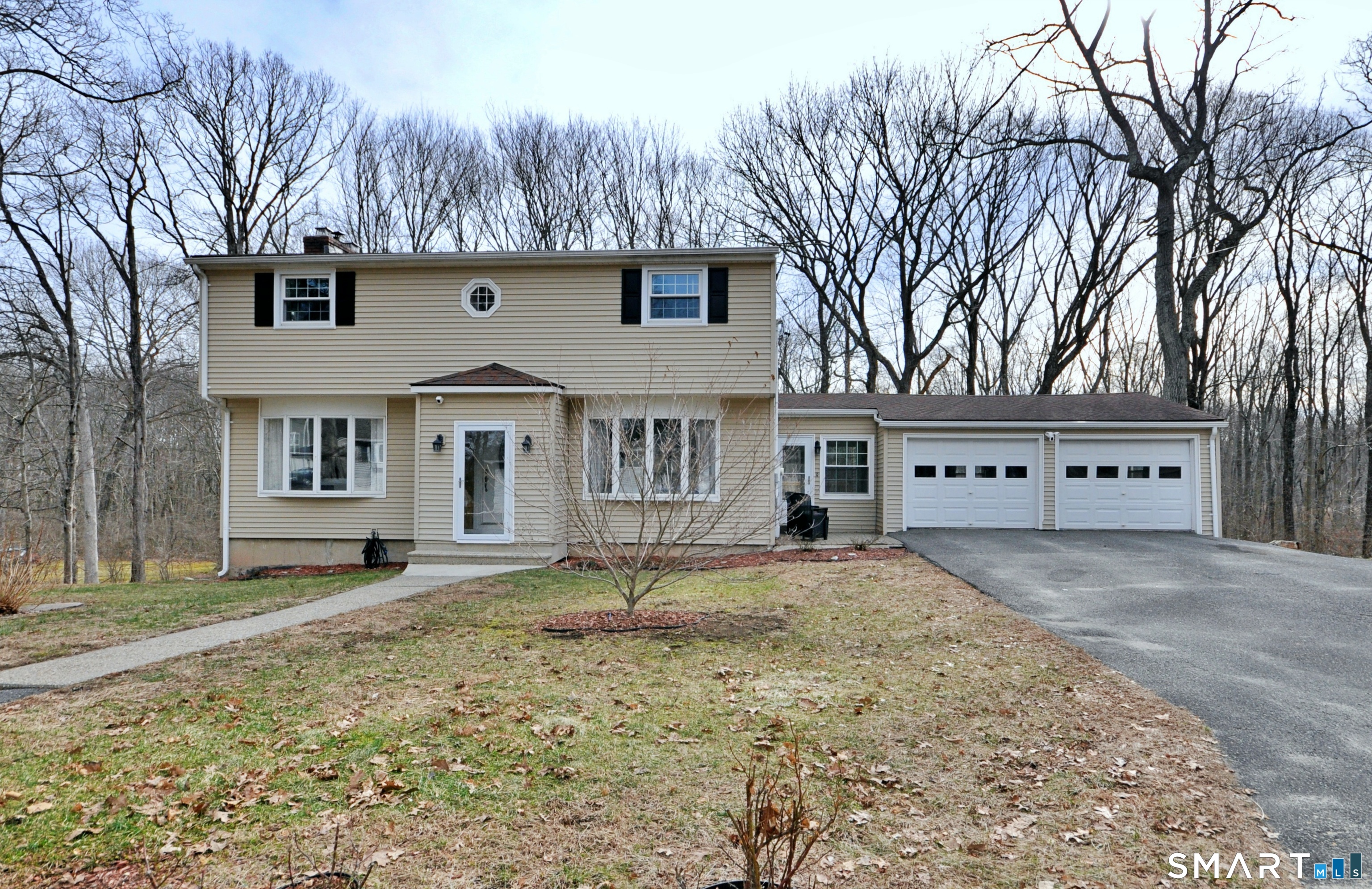 a front view of a house with a yard and trees
