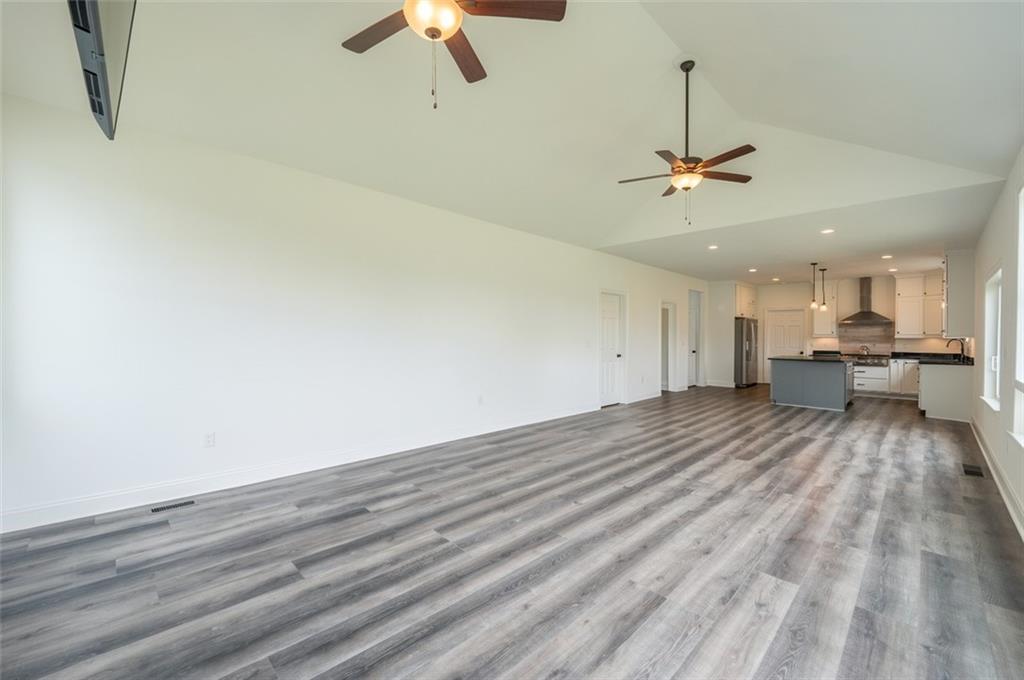 356 Stone Church Road Hunker, PA 15639 - Photo 10 of 40 a view of empty room with wooden floor and ceiling fan