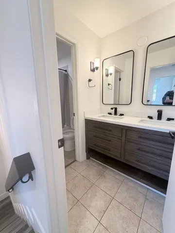 a bathroom with a double vanity sink mirror and toilet