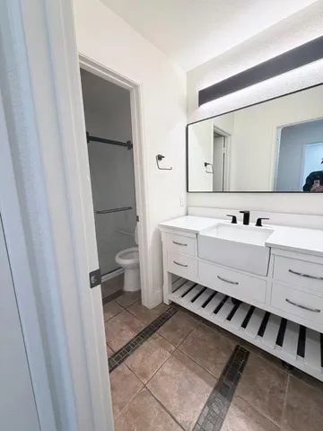a bathroom with a sink a toilet a mirror and vanity