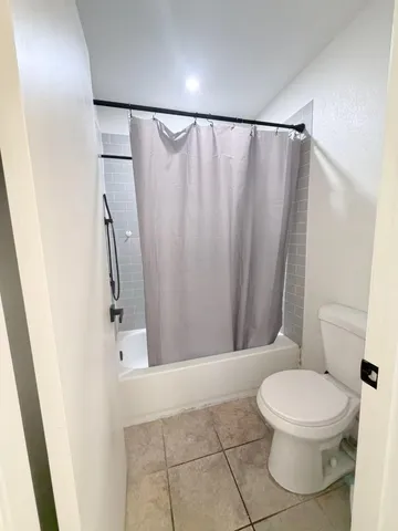 a white toilet sitting next to a shower curtain
