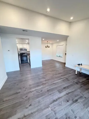 a view of empty room with wooden floor