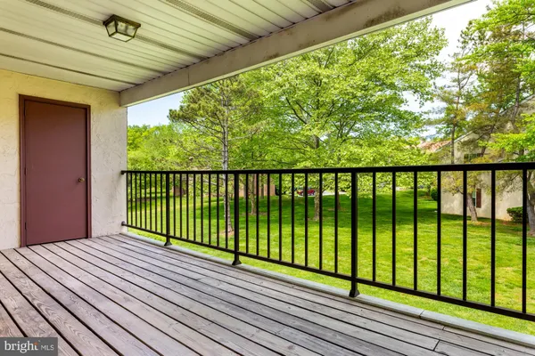 a view of balcony with wooden floor and fence