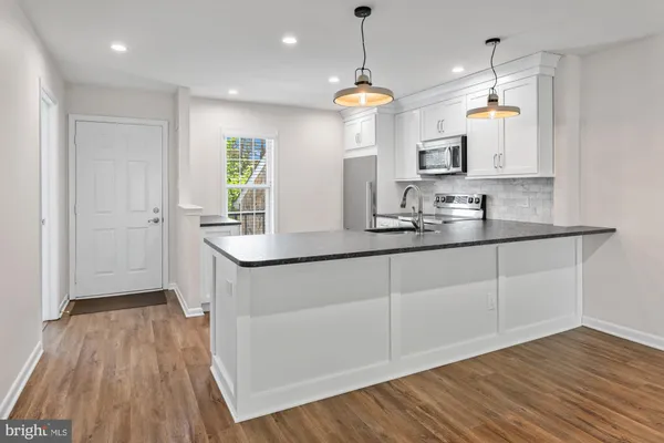 a kitchen with cabinets wooden floor and a window