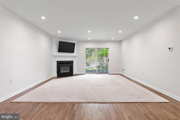 a view of an empty room with a fireplace and a window