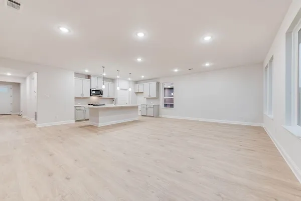 a view of kitchen with white cabinets and wooden floor