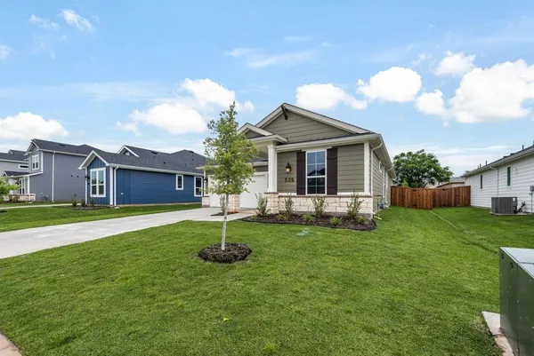 a front view of a house with a yard and trees