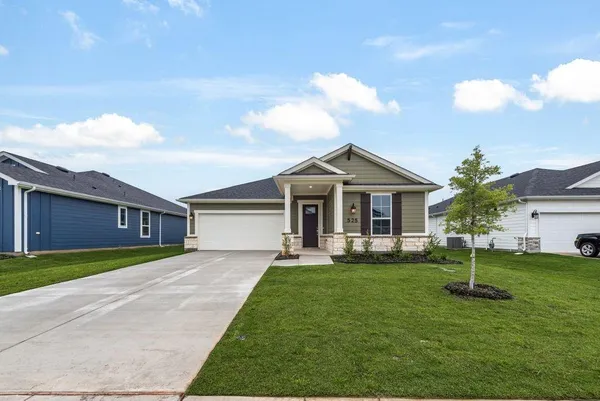 a front view of a house with a yard and trees
