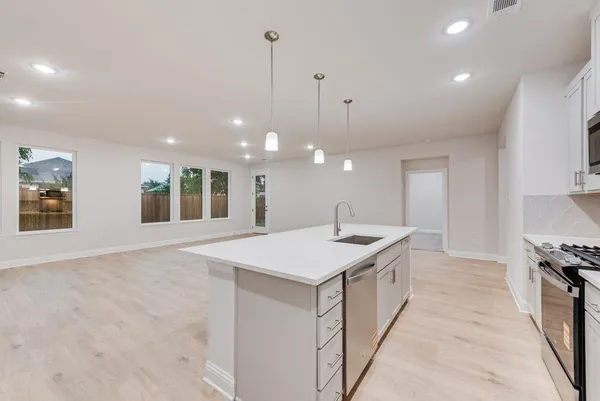 a kitchen with a sink and a stove top oven