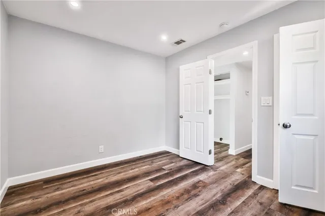 a view of a hallway with wooden floor and closet