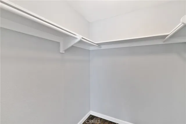 a view of empty room with wooden floor and fireplace
