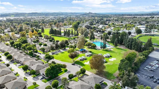 an aerial view of residential houses with outdoor space and trees