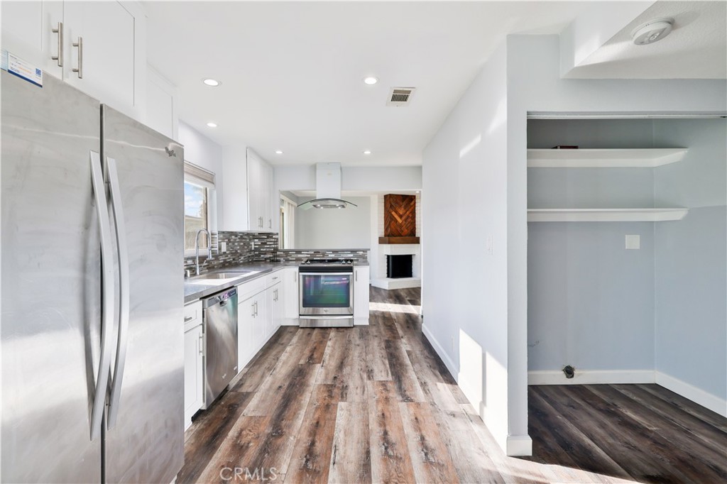 2702 College Lane La Verne, CA 91750 - Photo 5 of 53 a kitchen with white cabinets and stainless steel appliances