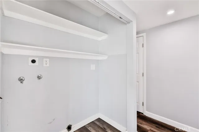 a view of a hallway with wooden floor and cabinets
