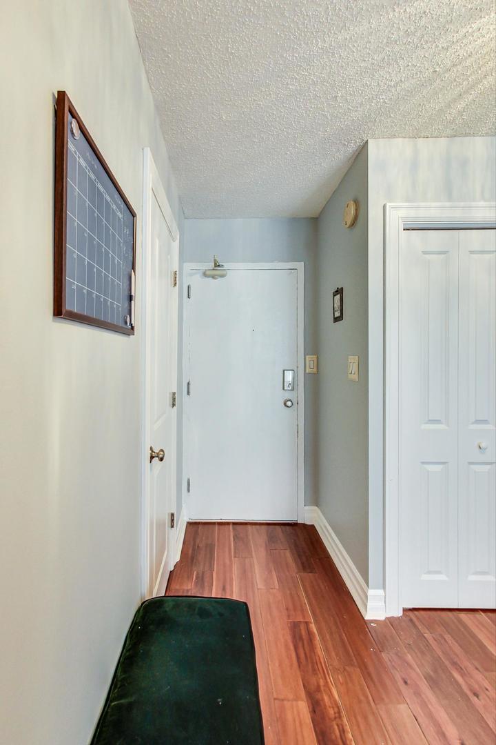 2930 North Sheridan Road, Unit 811 Chicago, IL 60657 - Photo 19 of 52 a view of a hallway with wooden floor and a bathroom