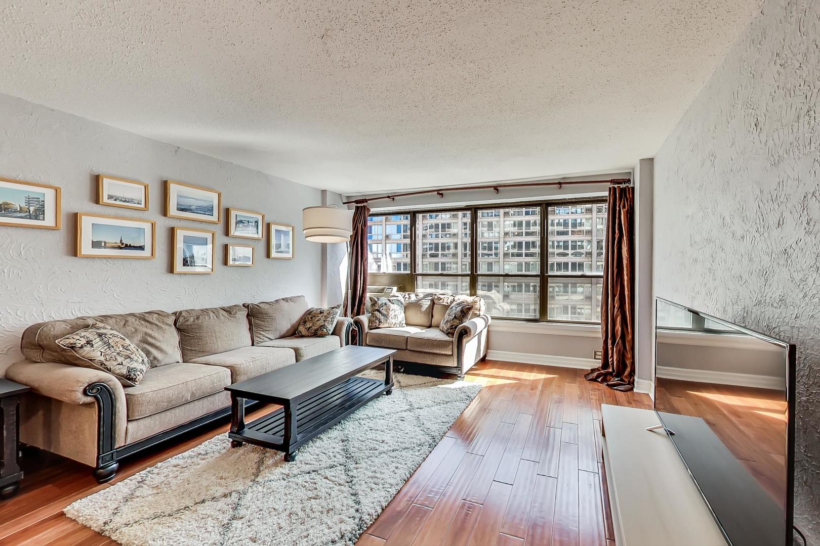 2930 North Sheridan Road, Unit 811 Chicago, IL 60657 - Photo 20 of 52 a living room with furniture and a large window