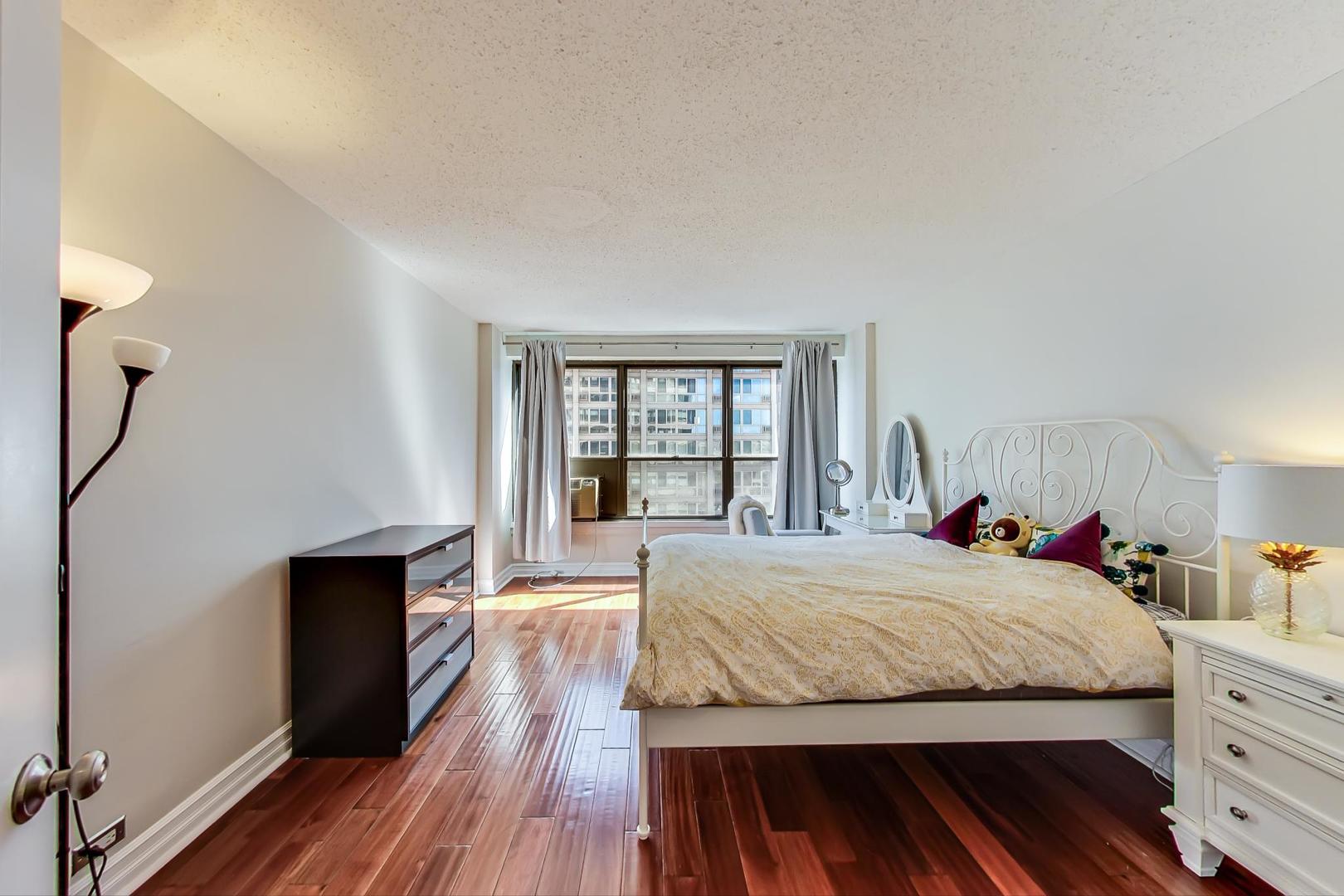 2930 North Sheridan Road, Unit 811 Chicago, IL 60657 - Photo 27 of 52 a bedroom with a bed and wooden floor