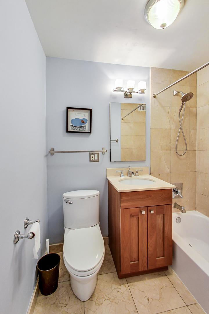 2930 North Sheridan Road, Unit 811 Chicago, IL 60657 - Photo 31 of 52 a bathroom with a toilet sink and mirror