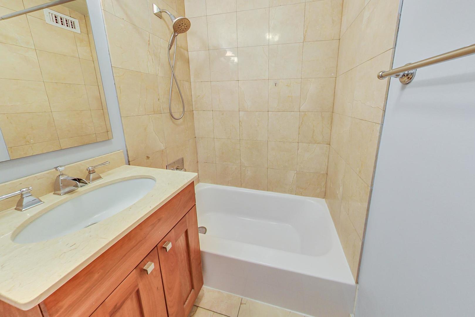2930 North Sheridan Road, Unit 811 Chicago, IL 60657 - Photo 32 of 52 a bathroom with a sink a mirror and a bathtub