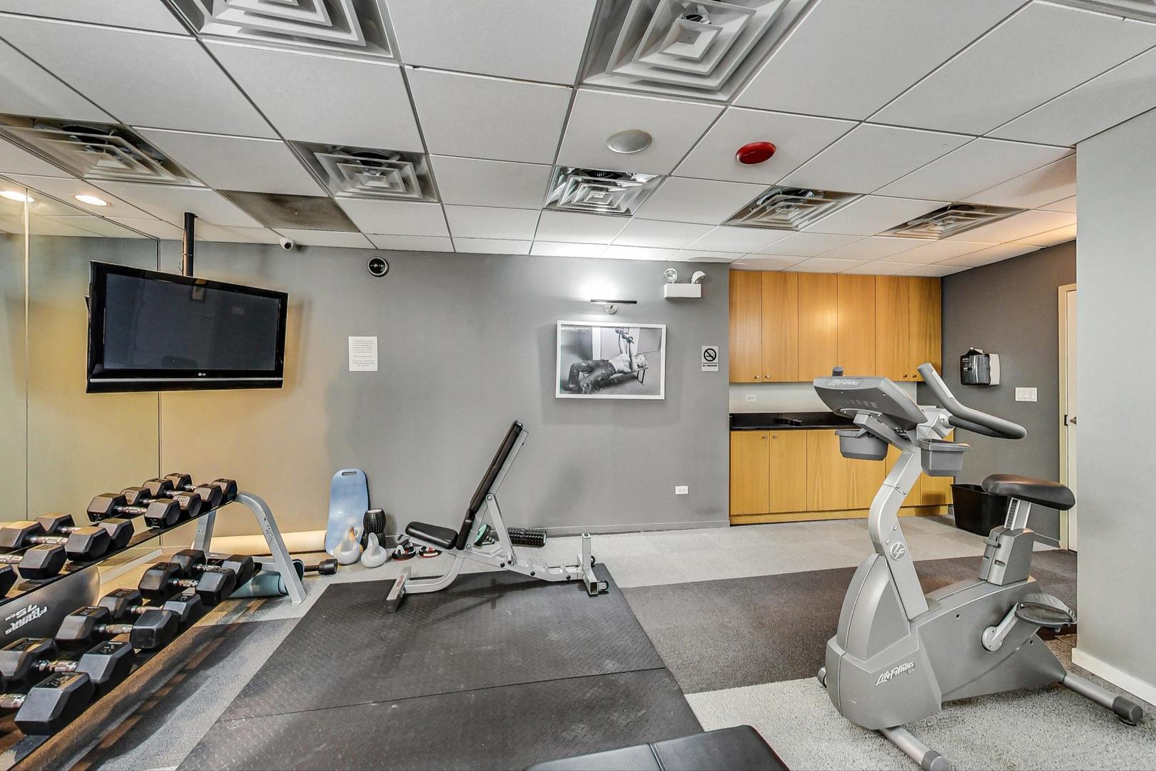 2930 North Sheridan Road, Unit 811 Chicago, IL 60657 - Photo 46 of 52 a room with gym equipment and a flat screen tv