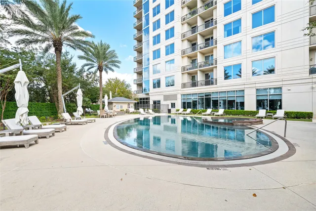 a view of swimming pool with outdoor seating and house in the background