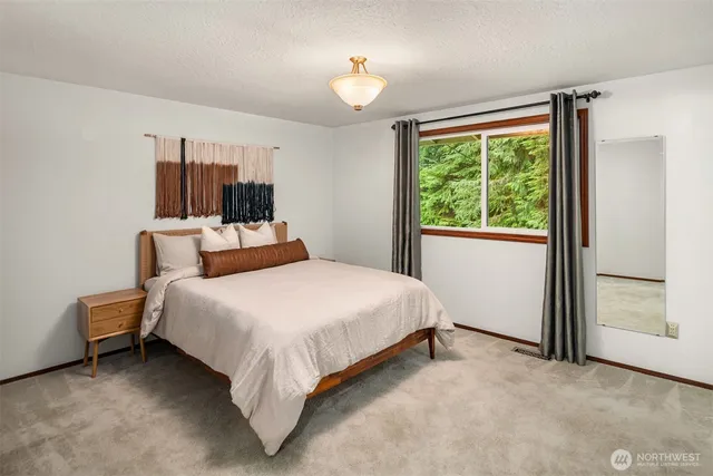 a bed sitting in a bedroom next to a window