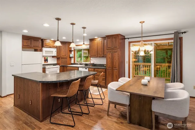 a dining room with furniture a chandelier and wooden floor