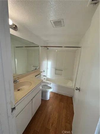 a bathroom with a granite countertop sink a toilet and shower