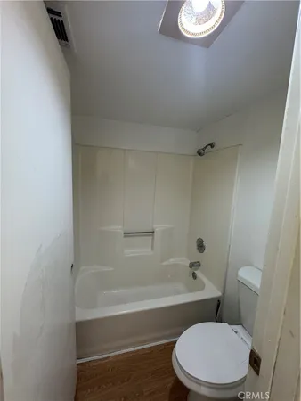 a white toilet and tub next to a white cabinet