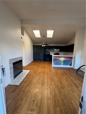 a living room with stainless steel appliances furniture a fireplace and a flat screen tv