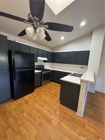 a room with kitchen island a counter top space a sink and stainless steel appliances