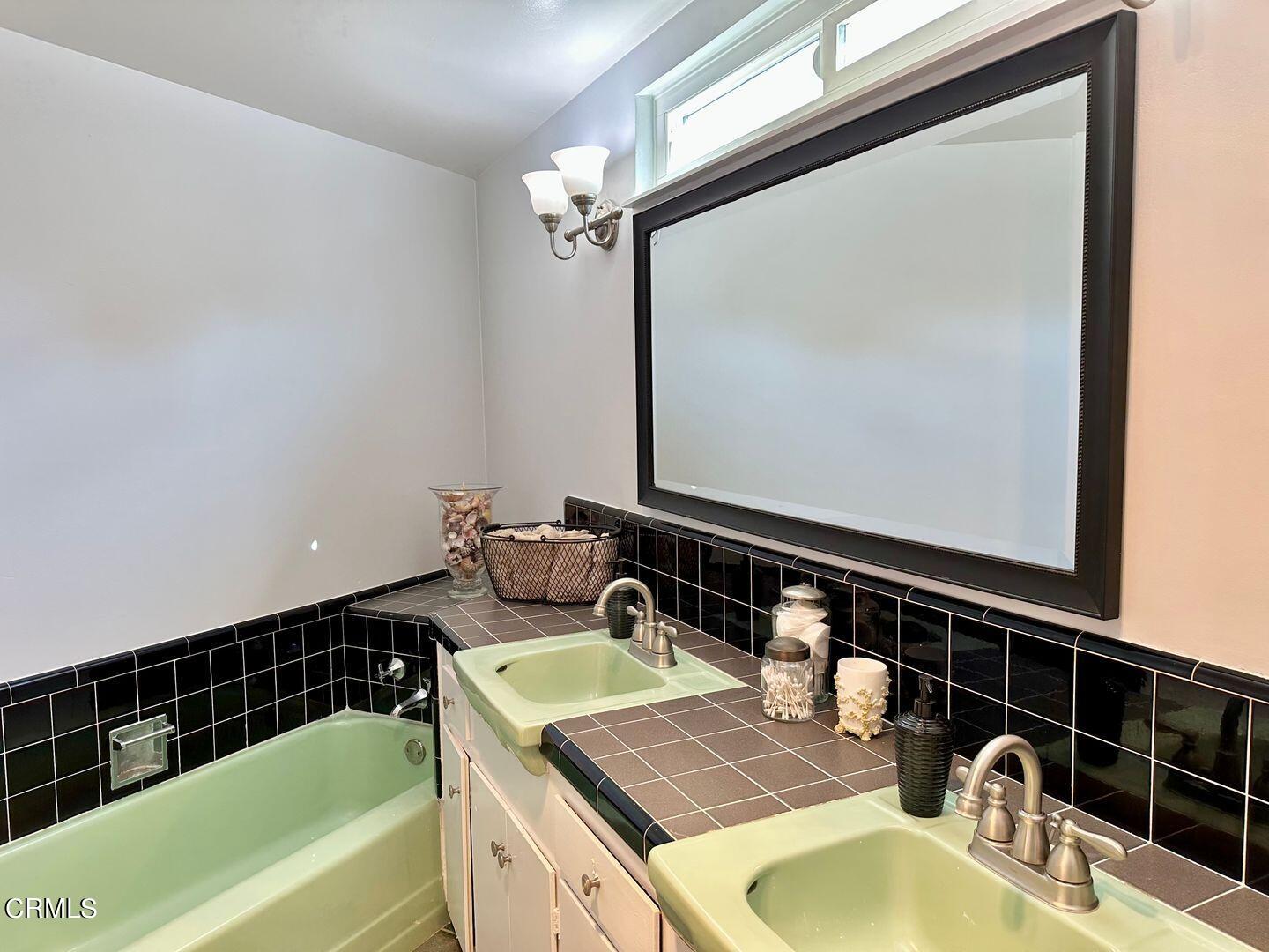 2201 Ocean Drive Oxnard, CA 93035 - Photo 21 of 30 a bathroom with a granite countertop sink and a mirror