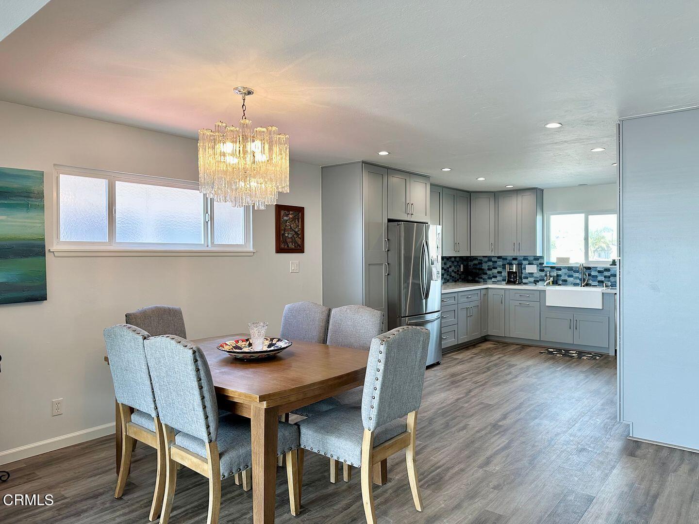 2201 Ocean Drive Oxnard, CA 93035 - Photo 3 of 30 a kitchen with a dining table chairs refrigerator and microwave