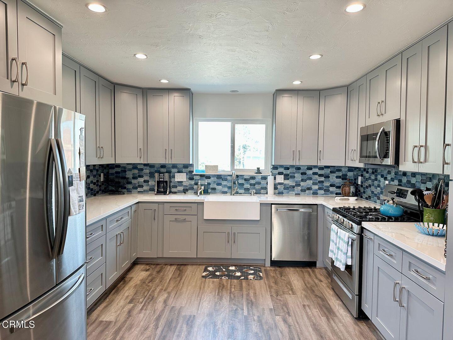 2201 Ocean Drive Oxnard, CA 93035 - Photo 4 of 30 a kitchen with white cabinets stainless steel appliances a sink and a window