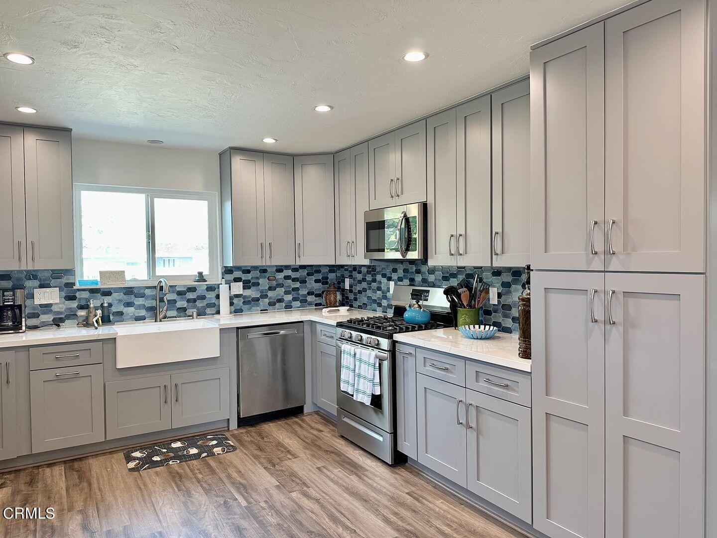 2201 Ocean Drive Oxnard, CA 93035 - Photo 6 of 30 a kitchen with white cabinets appliances and a sink