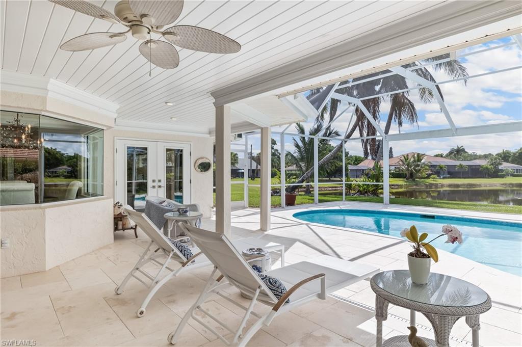 1904 Countess Court Naples, FL 34110 - Photo 13 of 33 a living room with a large window and a table