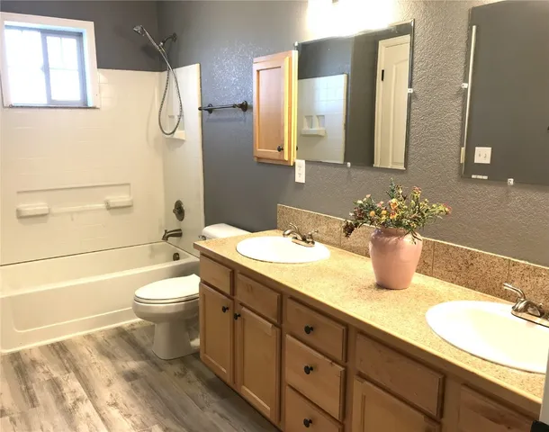 a bathroom with a granite countertop sink mirror vanity and toilet