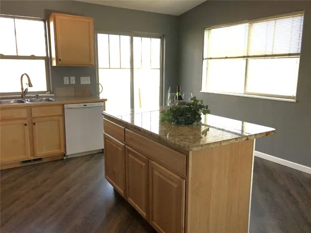 a kitchen with stainless steel appliances granite countertop a sink and a window