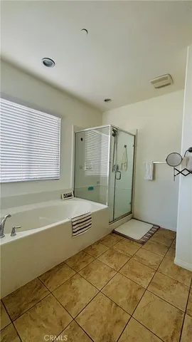 a bathroom with a tub a window and a shower