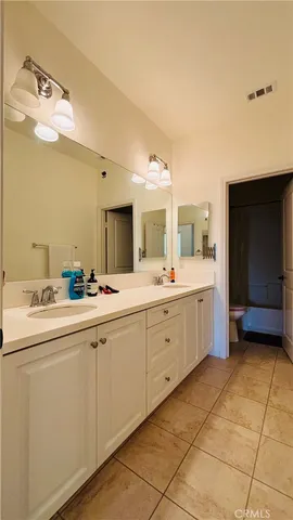 a spacious bathroom with a double vanity sink and a mirror
