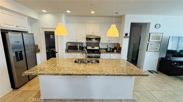 a kitchen with refrigerator and wooden floor
