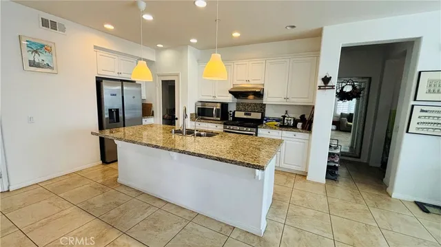 a kitchen with stainless steel appliances granite countertop a refrigerator and a sink
