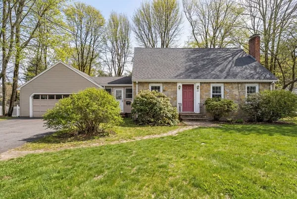 a front view of a house with a yard and trees