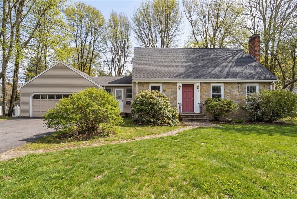 a front view of a house with a yard and trees