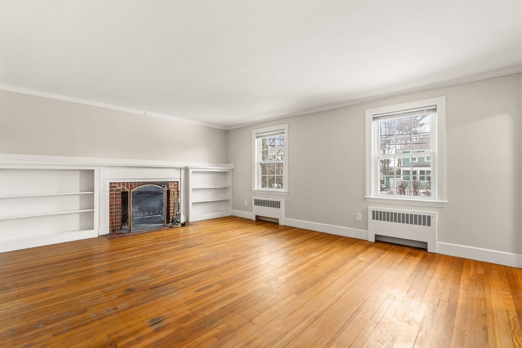 630 Pleasant Street Canton, MA 02021 - Photo 12 of 31 an empty room with wooden floor fireplace and windows