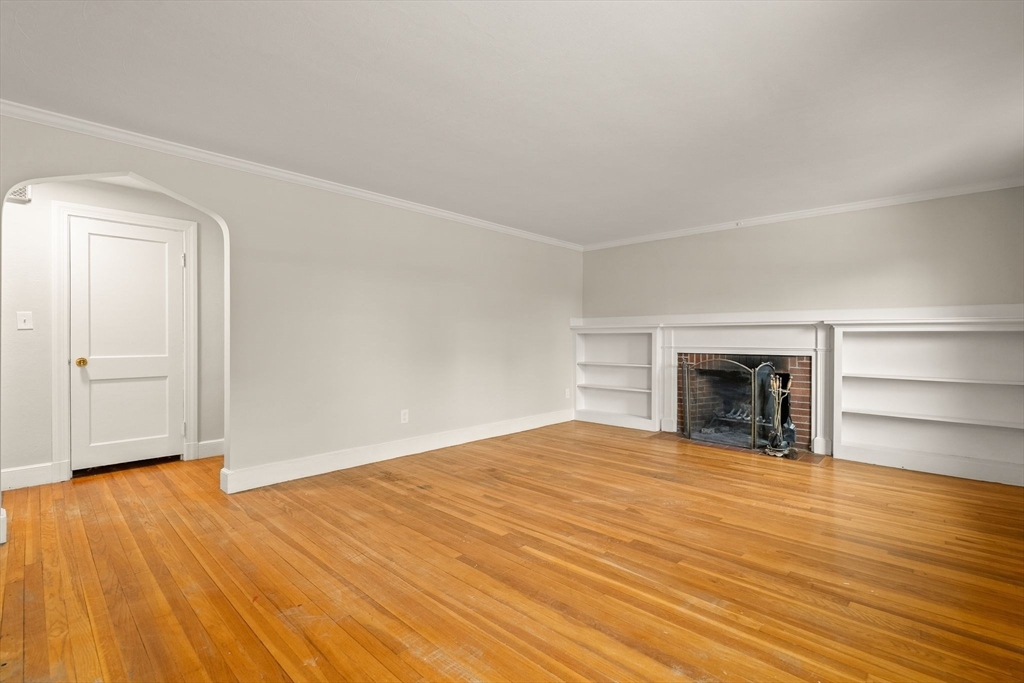 630 Pleasant Street Canton, MA 02021 - Photo 13 of 31 a view of an empty room with wooden floor fireplace and a window