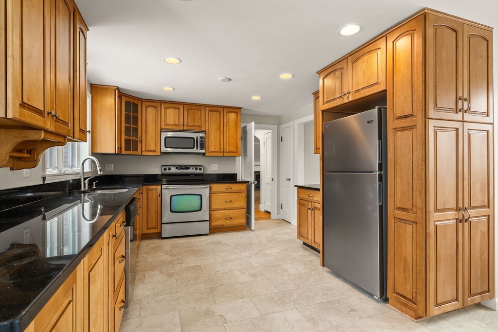 630 Pleasant Street Canton, MA 02021 - Photo 5 of 31 a kitchen with granite countertop a refrigerator and a sink
